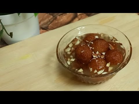 Close-up of golden brown Gulab Jamun soaking in sugar syrup